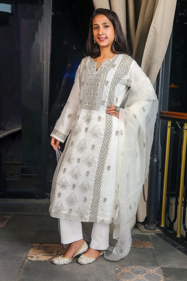 off-white organza chikankari suit, featuring intricate contrast thread embroidery and delicate pearl embellishments.