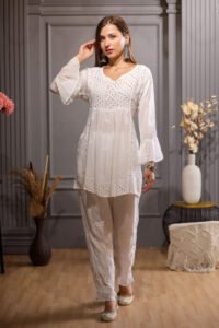 Short Kurta is designed with elegant chikankari and bold ghaas patti work.