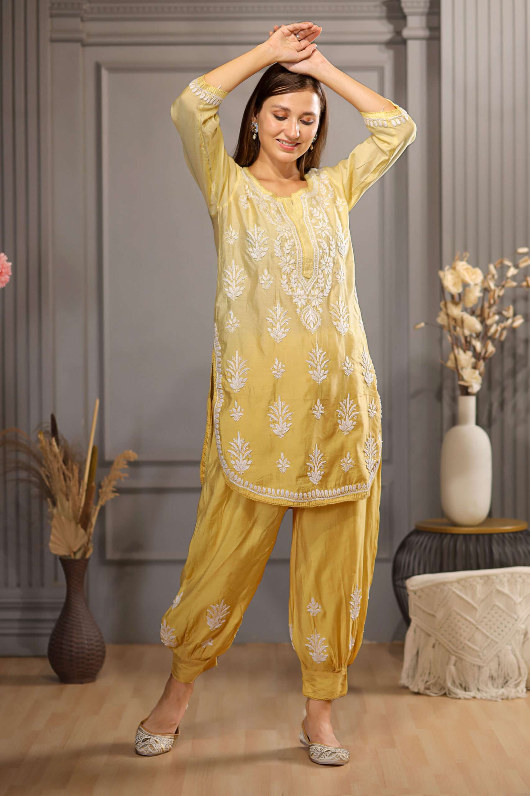 Pretty woman wearing yellow Kurta and afghani pant with detailed chikankari embroidery work on it.