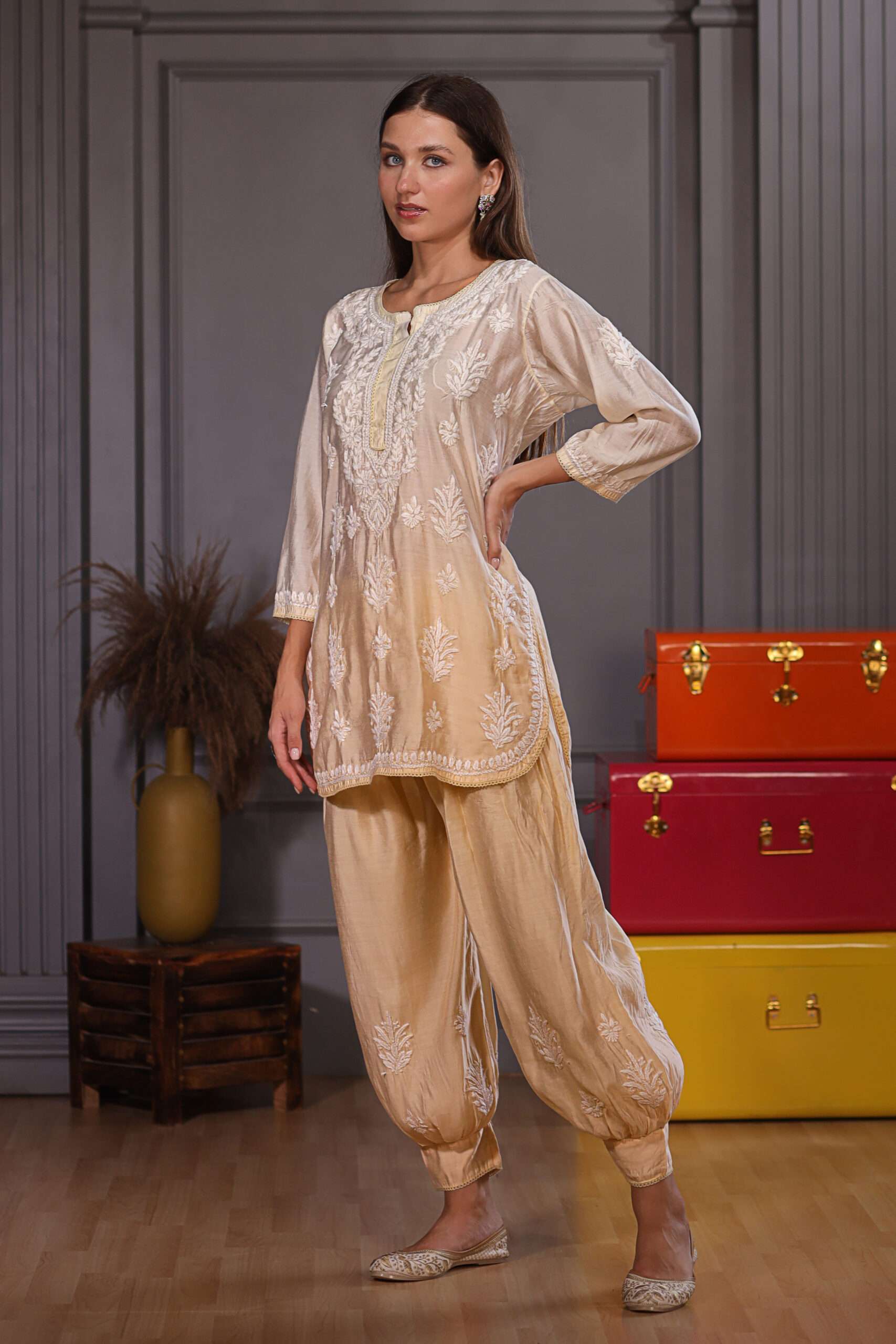 Pretty woman wearing beige Kurta and afghani pant with detailed chikankari embroidery work on it.