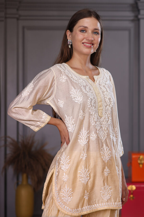 Pretty woman wearing beige Kurta and afghani pant with detailed chikankari embroidery work on it.